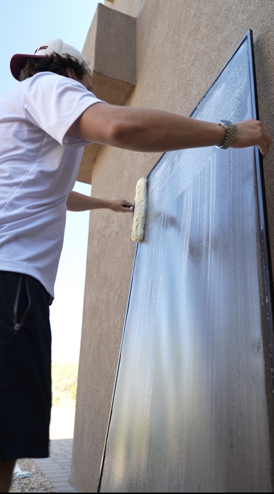 Apex tech scrubbing a solar panel by hand