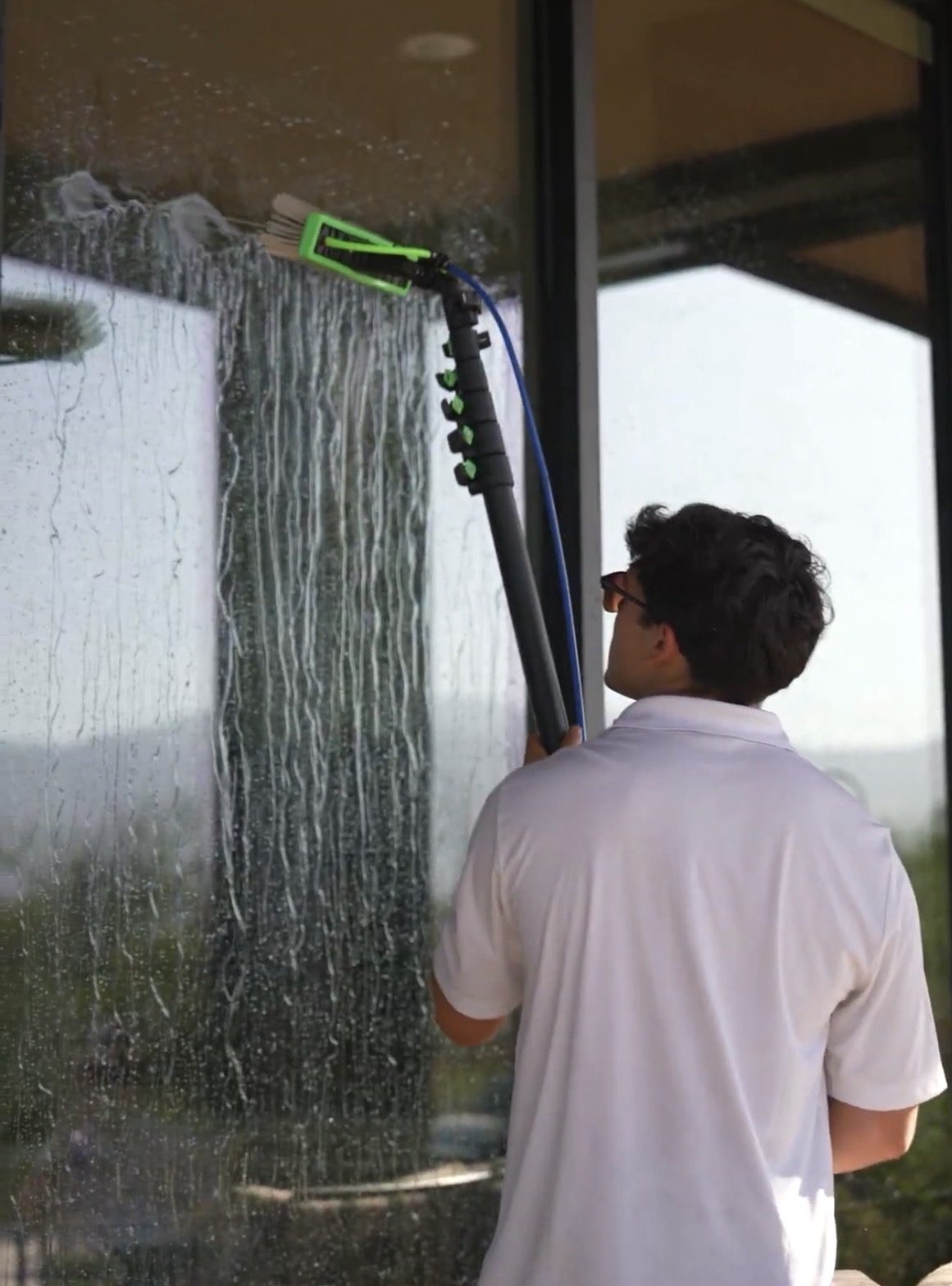 Apex tech cleaning an exterior window in Tucson