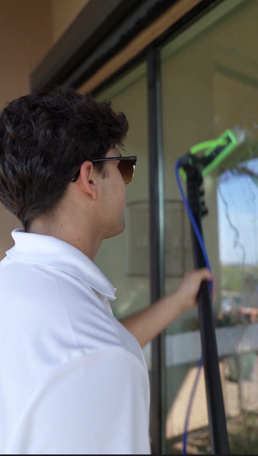Apex tech cleaning a sliding glass door with a squeegee